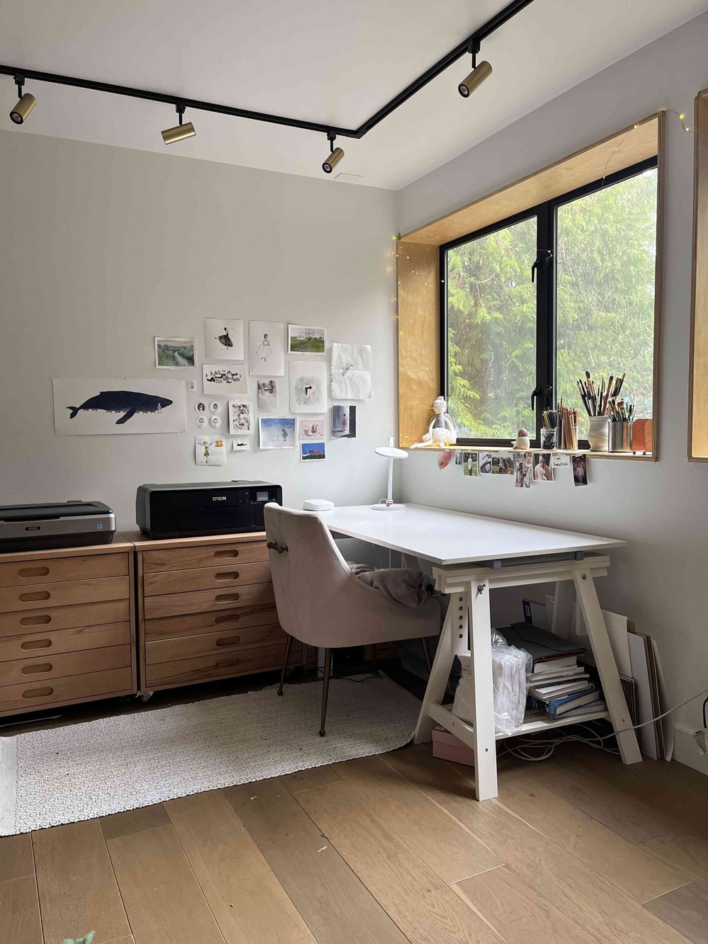 Tessa Blackham's illustration studio with a drafting table and artwork pinned to the wall